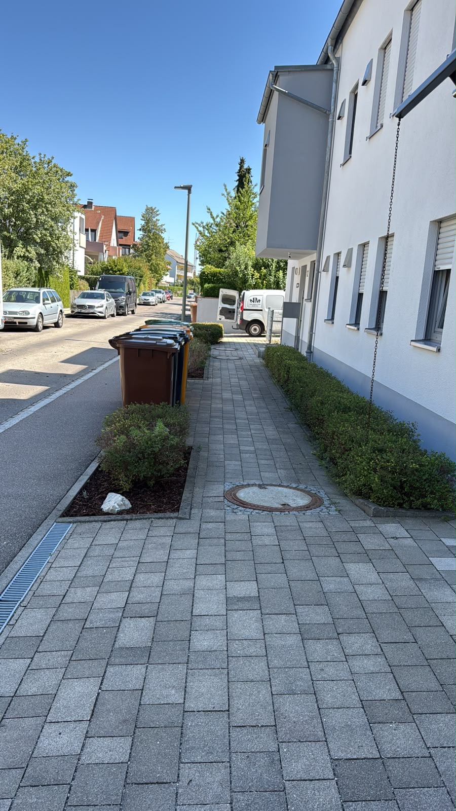 Gepflegter Außenbereich einer Wohnanlage mit Firmenfahrzeug